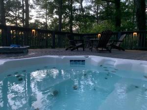 a swimming pool with two chairs and a table at Loblolly Pines Adventure Aframe #1 in Eureka Springs