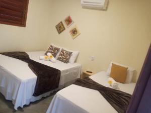 two beds sitting next to each other in a room at Chalé Mandacaru in Monte das Gameleiras