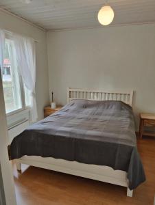 1 dormitorio con 1 cama con manta gris en Nicolas apartment, en Loimaa