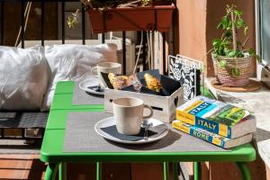 a green table with two cups of coffee and books at Dulcis In Colosseo Apartments in Rome