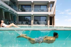 un hombre y una mujer nadando en una piscina en Akti Toroni Boutique Hotel en Toroni