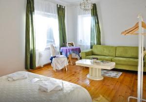 a living room with a green couch and a table at Irena Family House in Vilnius