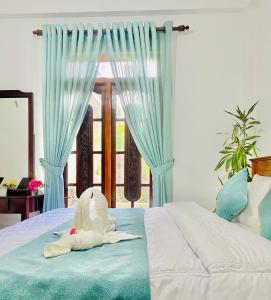 a bedroom with a bed with a stuffed animal on it at Highest Village Bungalow in Nuwara Eliya