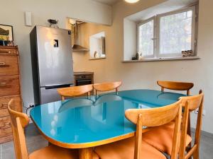 uma cozinha com uma mesa e cadeiras azuis e um frigorífico em Appartamento 109 con giardino esclusivo em Lucca
