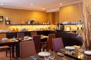 a restaurant with tables and chairs and a kitchen at Hotel The Augustin in Brussels