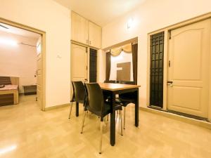 a dining room with a table and chairs at Aishwaryam Hotels & service Apartment in Madurai