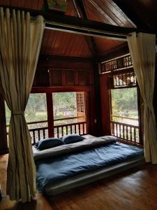 um quarto com uma cama num quarto com janelas em Mận Homestay - Lục Yên Homestay and Tour 