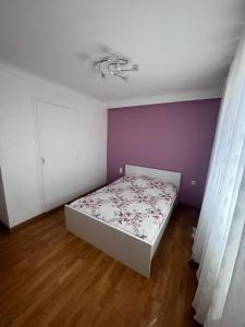 ein Schlafzimmer mit einem Bett und einer lila Wand in der Unterkunft Magnifique maison bord de mer Canet plage in Canet-en-Roussillon
