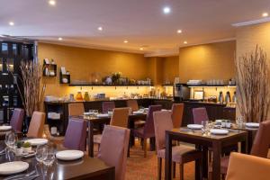 un restaurante con mesas y sillas y una cocina en Hotel The Augustin en Bruselas