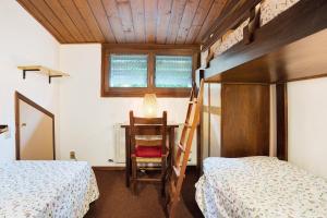 a bedroom with two beds and a desk and a ladder at Il Cirmolo in Madonna di Campiglio
