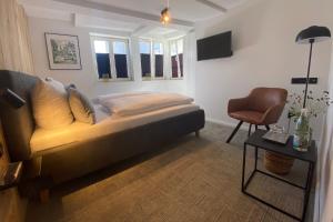 um quarto com uma cama, uma cadeira e uma mesa em Wertschätzer Hotel - Krumme Str em Detmold