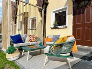 a patio with two chairs and a couch and a table at Klara w Ogrodzie in Łeba