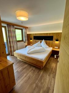 アルプバッハにあるAppartements Kolberhofのベッドルーム(白い枕の大きな木製ベッド付)