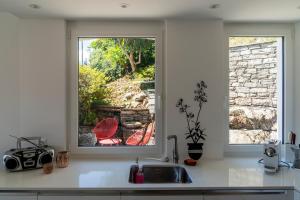 a kitchen with a sink and two windows at Orselina in Style in Orselina