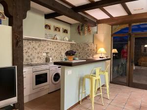 a kitchen with white appliances and yellow stools at Casa Rural La Ferrería in Vinuesa +17 photos