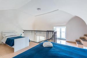 Habitación blanca con cama y alfombra azul en La TERRAZZA sul GIARDINO, en Procida