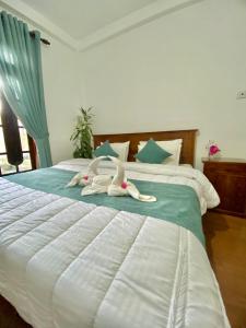two stuffed animals laying on top of a bed at Highest Village Bungalow in Nuwara Eliya
