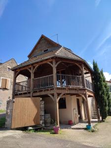 uma grande casa de madeira com um alpendre e uma varanda em Le Clos du Château em Rully