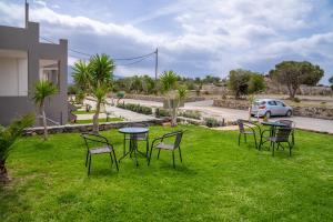 a group of chairs and tables in the grass at Lafo Rooms in Elafonisi