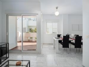 a white dining room with a table and black chairs at 2051-New 3 bedrooms on golf in Estepona