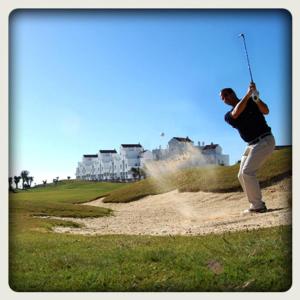 a man swinging a baseball bat on a golf course at 2051-New 3 bedrooms on golf in Estepona