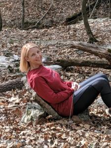 uma mulher sentada numa rocha na floresta em Loblolly Pines Adventure Aframe #2 em Eureka Springs