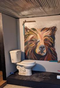 a bathroom with a painting of a bear on the wall at Loblolly Pines Adventure Aframe #2 in Eureka Springs
