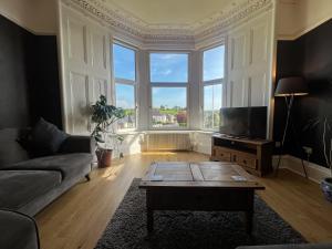 a living room with a couch and a coffee table at A Spacious Flat with Character - Private Car Space in Paisley