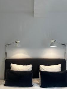 twee kussens op een bed met daarboven twee lampen bij Le Vieux Moulin in Marche-en-Famenne +17 foto's