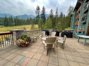 eine Terrasse mit Tischen und Stühlen auf dem Balkon in der Unterkunft Snow Creek Lodge by Fernie Central Reservations in Fernie