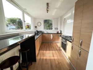 a kitchen with wooden cabinets and a counter top at A Spacious Flat with Character - Private Car Space in Paisley