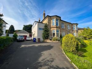 una casa con un coche aparcado delante de ella en A Spacious Flat with Character - Private Car Space en Paisley