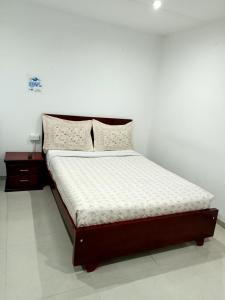 a bed in a room with a white wall at Stay In Bogota in Bogotá