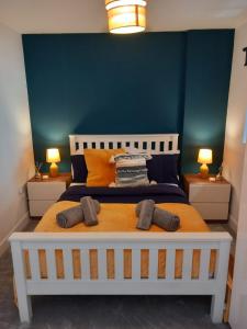 a bedroom with a large bed with a blue wall at Stylish One Bedroom City Centre Apartment with Free Parking in Birmingham