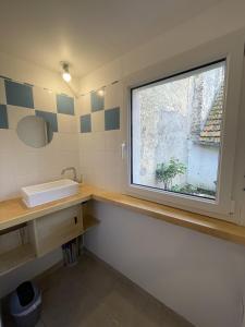 ein Bad mit einem Waschbecken und einem Fenster in der Unterkunft Maison d'artiste entre Beauval et Cheverny in Contres