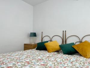 uma cama com almofadas amarelas e verdes em Modern apartment on the beach with pool em Calpe