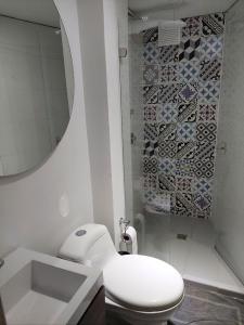y baño con aseo, lavabo y espejo. en Hermoso Apartamento amoblado, excelente ubicación, en Manizales