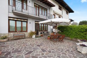 a patio with an umbrella and a table and bench at Cascina Nonna Nina in Credaro