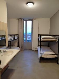 里昂的住宿－Hostel Lyon Centre HI，一间带两张双层床和盥洗盆的浴室