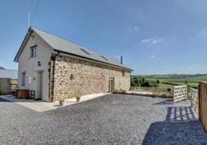 a building with a gravel driveway in front of it at Barton Barn in Bishops Nympton
