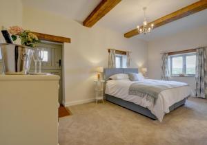 a bedroom with a large bed and a window at Barton Barn in Bishops Nympton