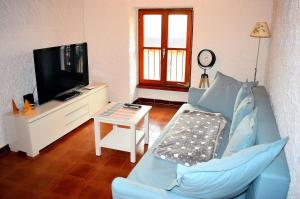 a living room with a blue couch and a tv at Il Rustico 2 in Castel San Pietro