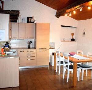 a kitchen with a wooden table and a dining room at Il Rustico 2 in Castel San Pietro
