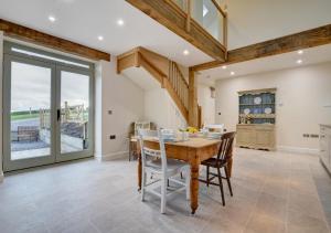 a dining room with a wooden table and chairs at Barton Barn in Bishops Nympton