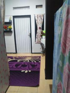 una porta con un tappeto viola di fronte a una camera di Homestay hafizh a Pasirwangi
