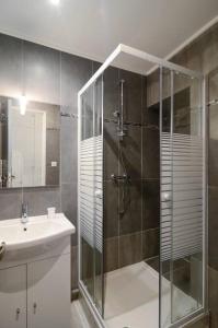 een badkamer met een glazen douche en een wastafel bij Ile d'Art in Pont-Aven