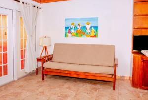 uma sala de estar com um sofá e um candeeiro em Mayan Princess Hotel em San Pedro