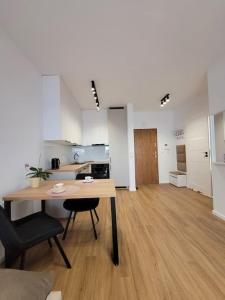 een kamer met een tafel en stoelen en een keuken bij Apartament 1410 in Suwałki
