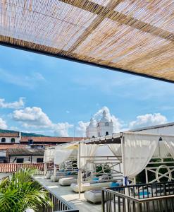 una terraza con sillas y sombrillas en el techo en Matisia Hotel Boutique, en Guaduas