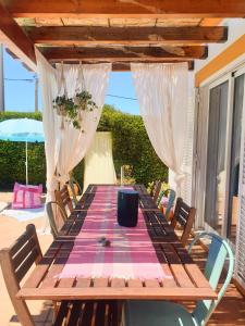 a wooden table on a patio with a tablecloth on it at Casa Ensolarada B&B and Pottery in Aljezur